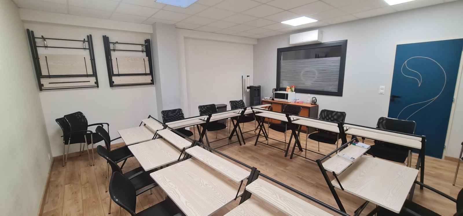 Salle de 35 m² organisée en tables de travail modulables.
