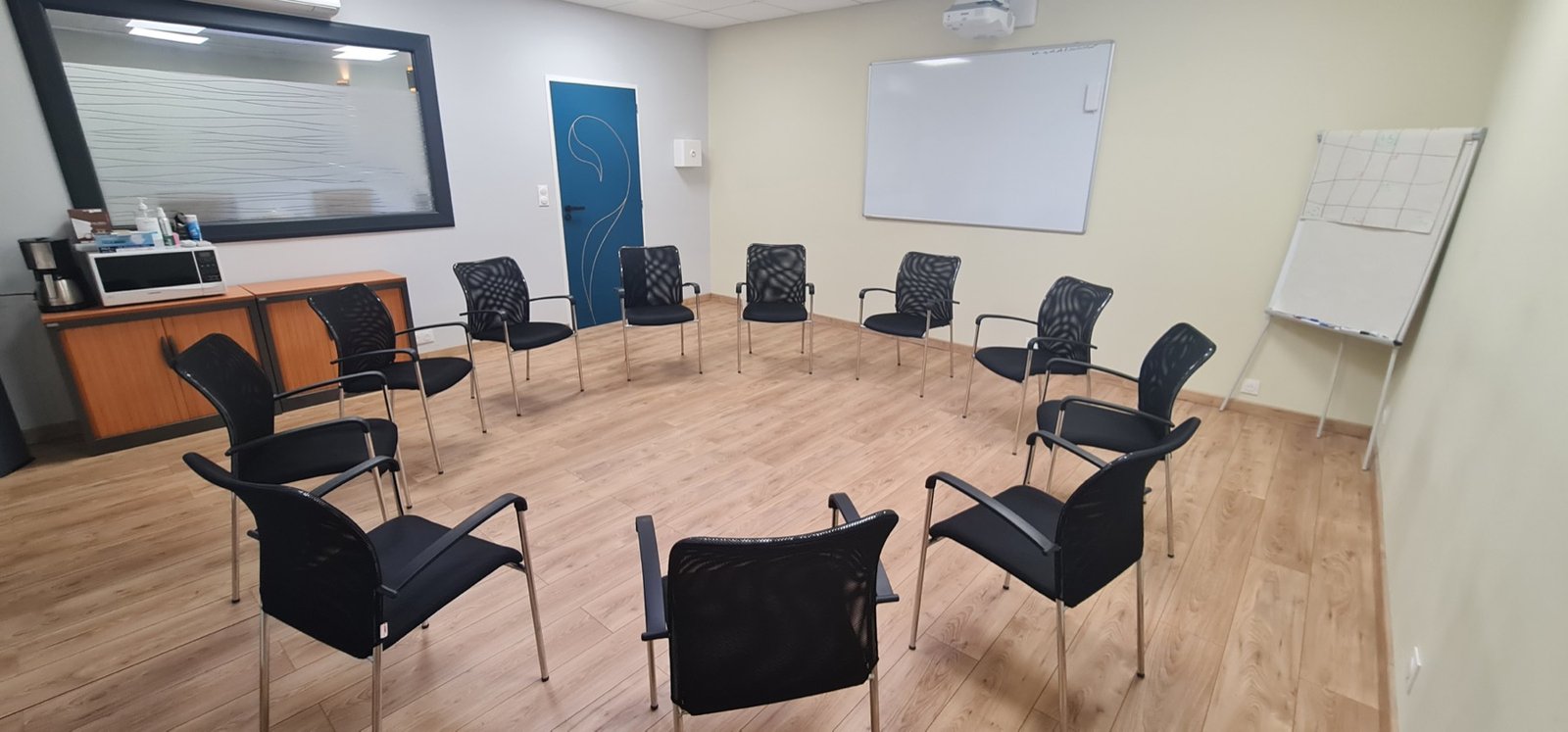Vue large de la salle de 35 m² avec chaises, tableau blanc et vidéoprojecteur.